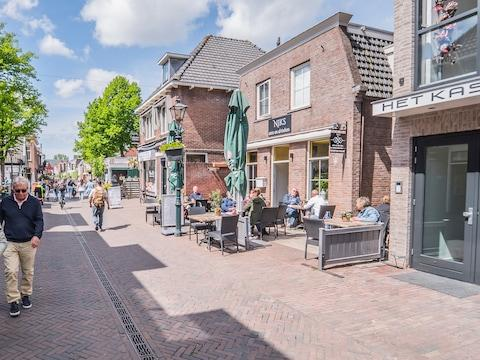 People walking through Zoetermeer streets with shops, cafés, and local activity.