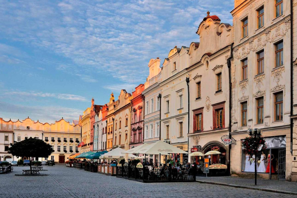 People walking through Pardubice streets with shops, cafés, and local market activity
