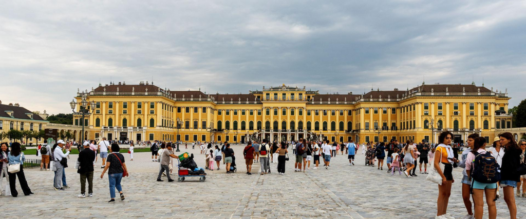 Tourists visiting Schönbrunn Palace in Vienna with historic architecture and gardens.