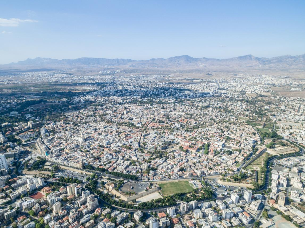 An aerial view of Nicosia featuring the city skyline with the Venetian walls and surrounding urban area.