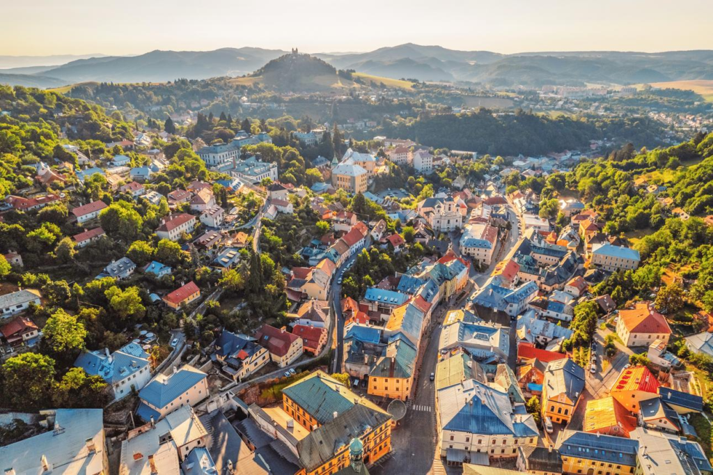 An aerial view of Banská Štiavnica showing the historic town nestled among hills and mountains.