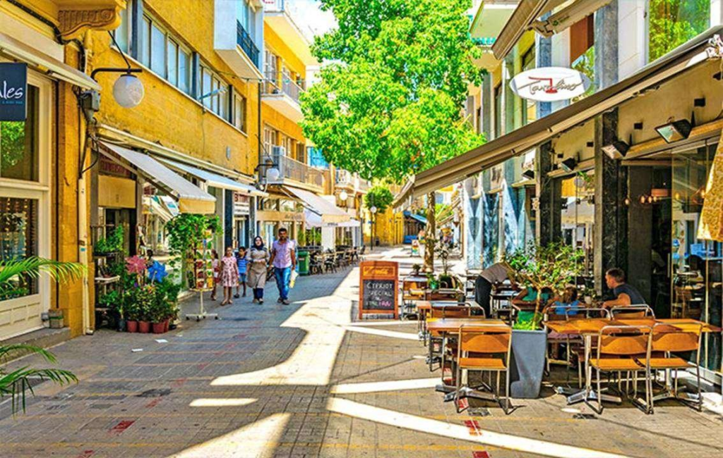 People walking through Nicosia streets with shops, cafés, and local market activity.