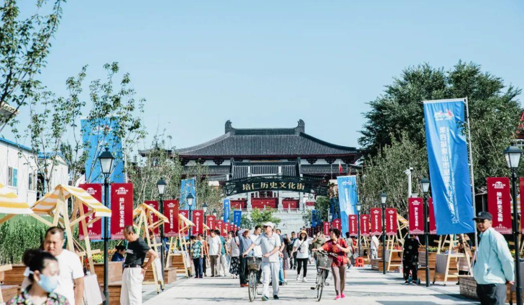 People walking through Tangshan streets with shops, cafés, and local market activity.
