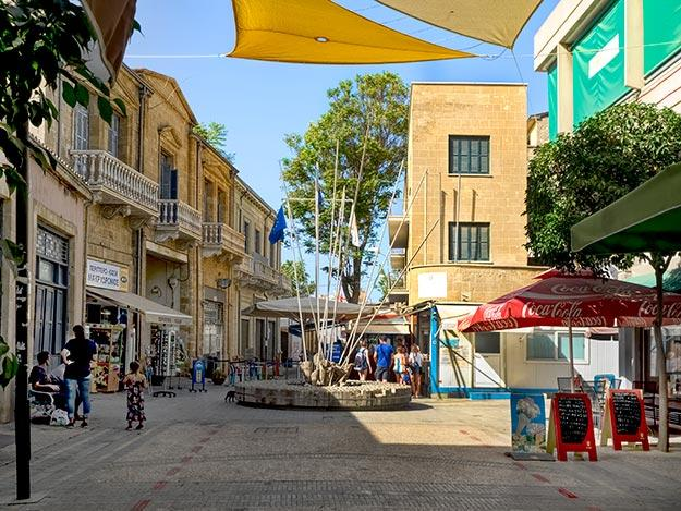 Tourists walking along Ledra Street in Nicosia with historic buildings and shops.