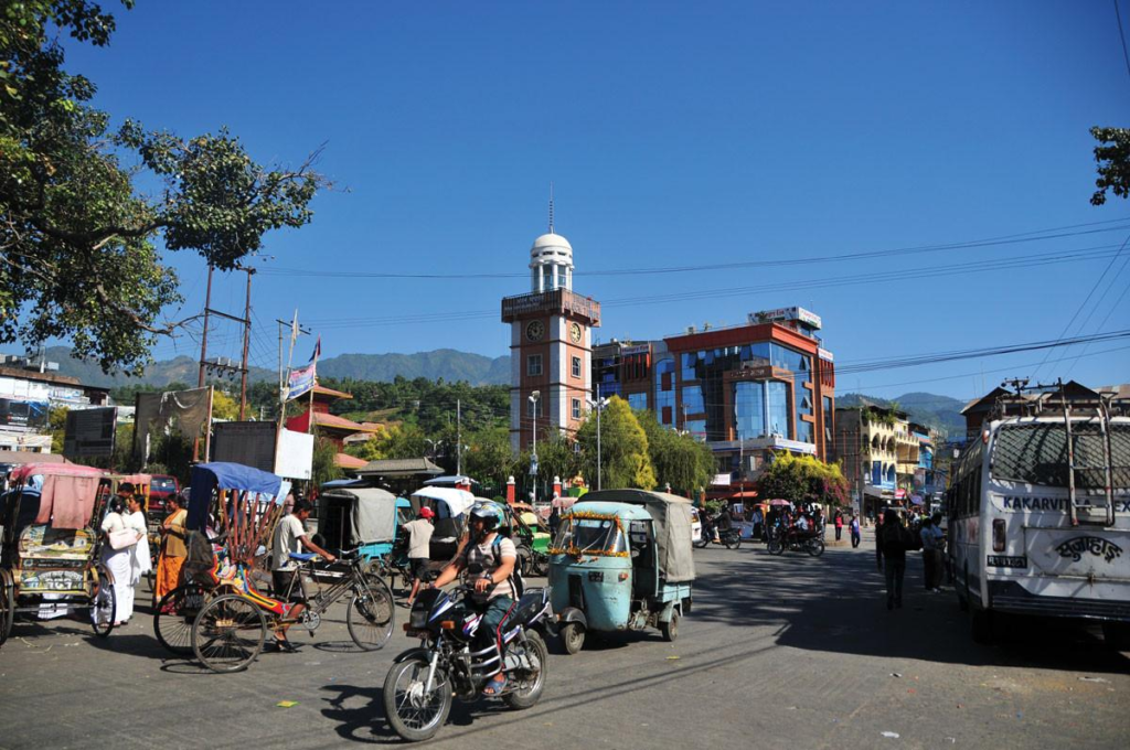 Visitors walking through streets in Dharan with local shops, markets, and pedestrian activity.