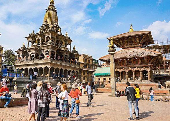 Visitors exploring Patan Durbar Square in Lalitpur, surrounded by historic temples and traditional architecture.