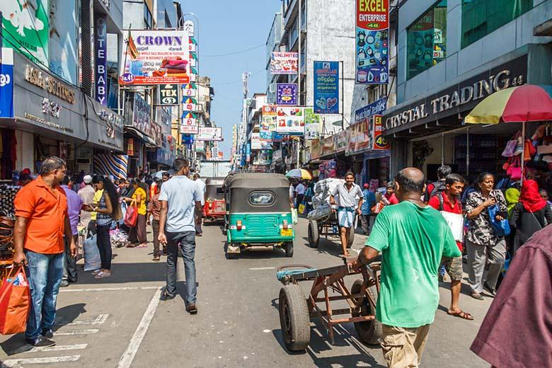 Visitors walking through streets in Colombo with local markets, shops, and pedestrian activity.