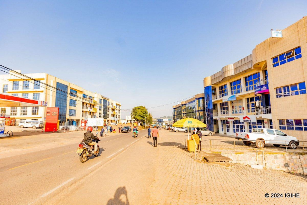 Visitors walking through streets in Muhanga with local markets, shops, and pedestrian activity.