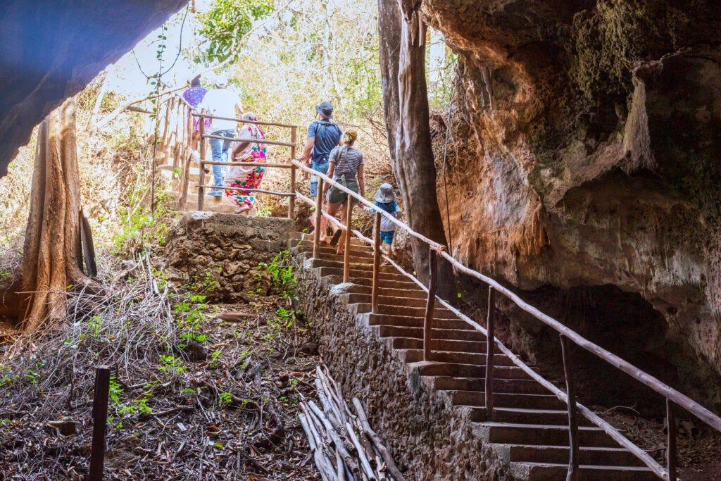 Visitors exploring the Amboni Caves near Tanga, Tanzania, featuring limestone formations.