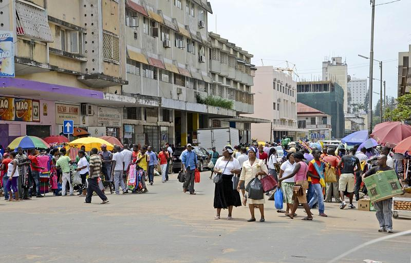 Visitors walking through streets in Maputo with local markets, shops, and pedestrian activity.
