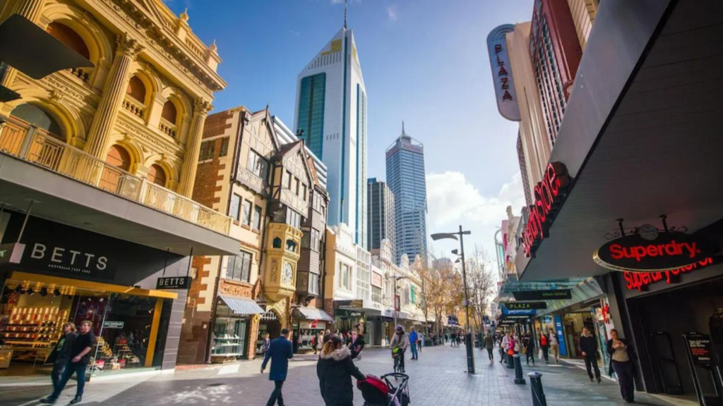 People walking through Perth streets with shops, cafés, and local market activity.