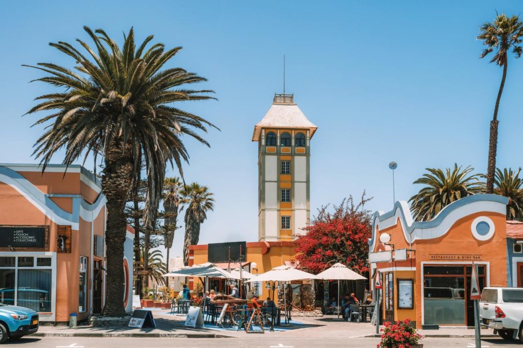 Visitors walking through streets in Swakopmund with cafés, shops, and German colonial-style buildings.