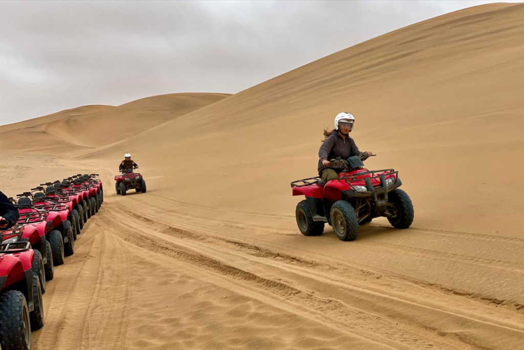 Visitors exploring sand dunes near Swakopmund, Namibia, with desert landscapes and outdoor activities.