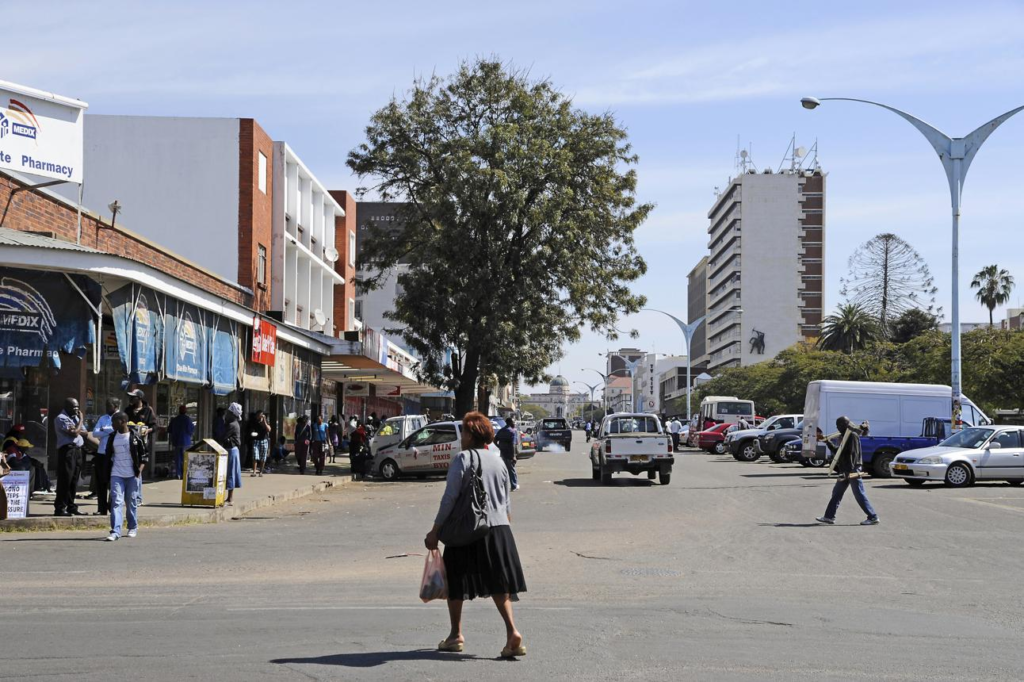 Visitors walking through streets in Bulawayo with shops, markets, pedestrians, and historic architecture.