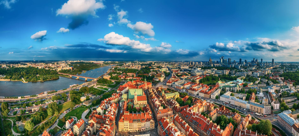 An aerial view of Warsaw showing the city skyline and the Vistula River.