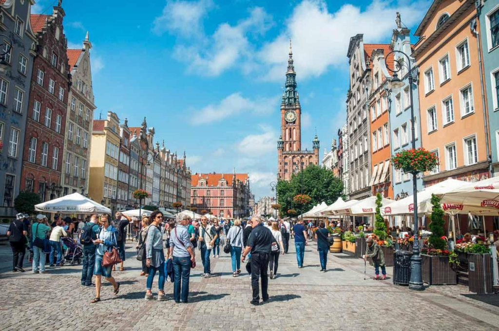 Tourists visiting Long Market in Gdańsk surrounded by historic buildings and vibrant street life.