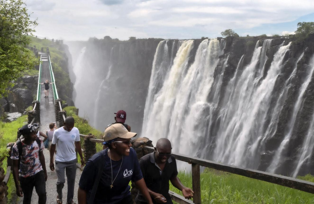 Visitors exploring the Victoria Falls area near Livingstone, Zambia, with river gorge and waterfalls.
