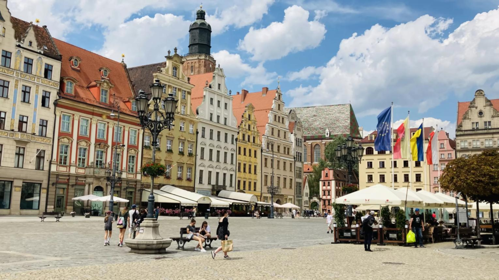 Tourists visiting Wrocław’s Market Square surrounded by historic buildings and colorful architecture.