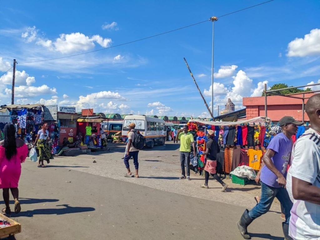 Visitors walking through streets in Lusaka with local markets, shops, and pedestrian activity.