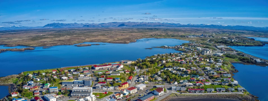A panoramic aerial view of Kópavogur showing the cityscape, coastline, and surrounding landscapes in Iceland’s Capital Region.
