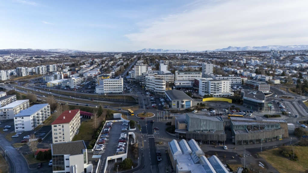 Visitors walking through streets in Kópavogur with shops, cafés, and pedestrian activity.