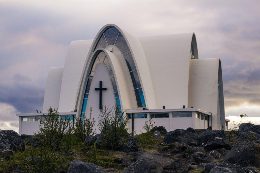 Visitors exploring Kópavogskirkja, a modern church in Kópavogur, Iceland, highlighting architectural design.