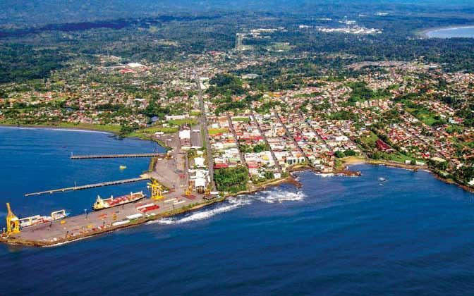A panoramic aerial view of Limón showing the cityscape, harbor, and Caribbean coastline in Costa Rica.