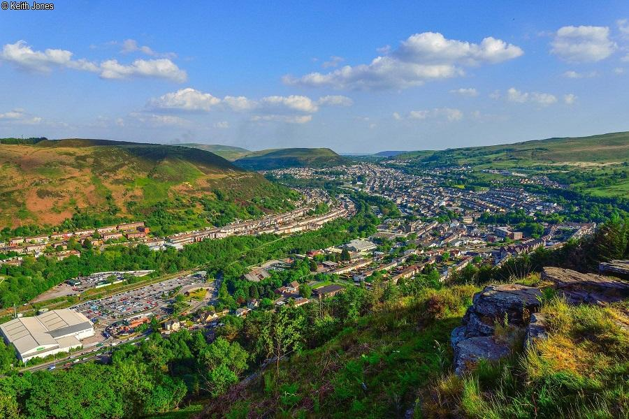 A panoramic aerial view of the Rhondda Valley showing rolling hills, towns, and surrounding landscapes in Wales, UK.