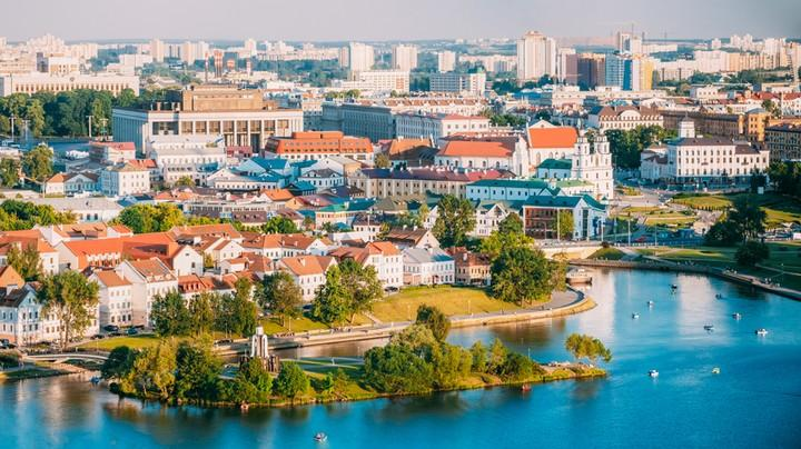 An aerial view of Białystok showing the city skyline with rivers and green parks.