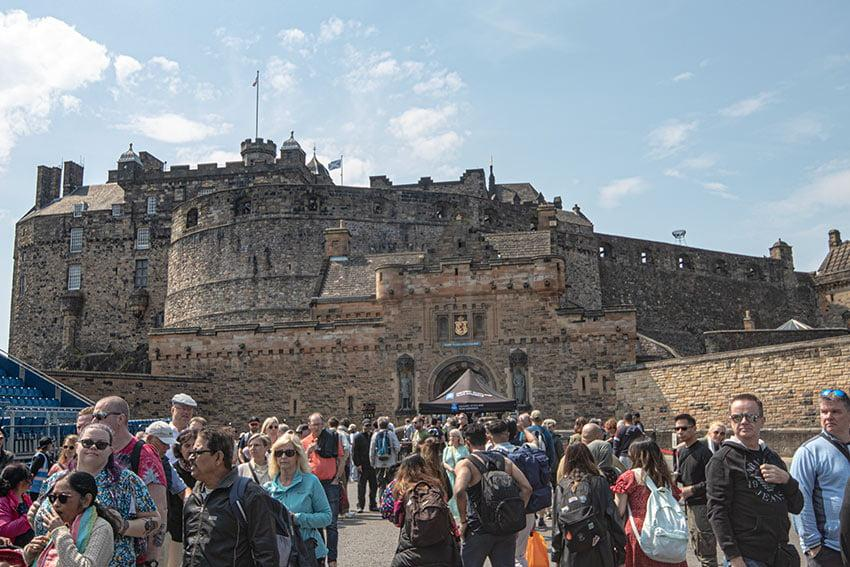 Visitors exploring Edinburgh Castle in Scotland, a historic landmark overlooking the city.