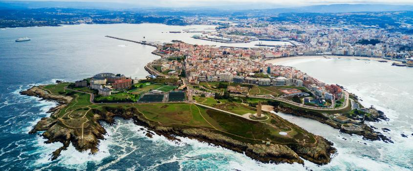 A panoramic aerial view of A Coruña showing the cityscape, coastline, and harbor in Galicia, Spain.
