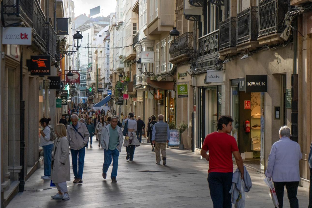 Visitors walking through streets in A Coruña with local shops, cafés, and pedestrian activity.