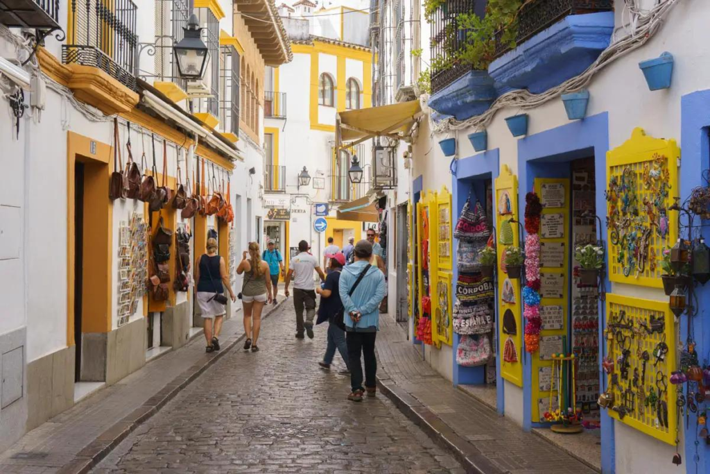 Visitors walking through streets in Córdoba with local shops, cafés, and pedestrian activity in the historic center.
