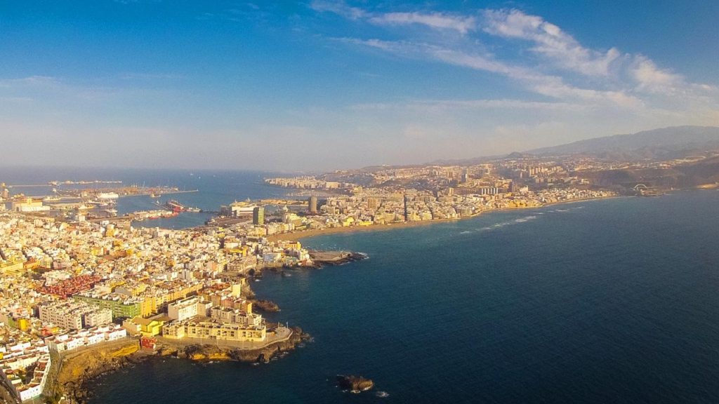 A panoramic aerial view of Las Palmas showing the cityscape, coastline, and harbor in the Canary Islands, Spain.