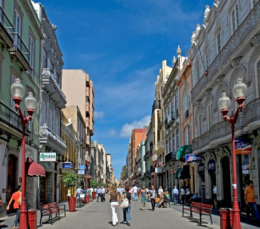 Visitors walking through streets in Las Palmas with shops, cafés, and pedestrian activity.