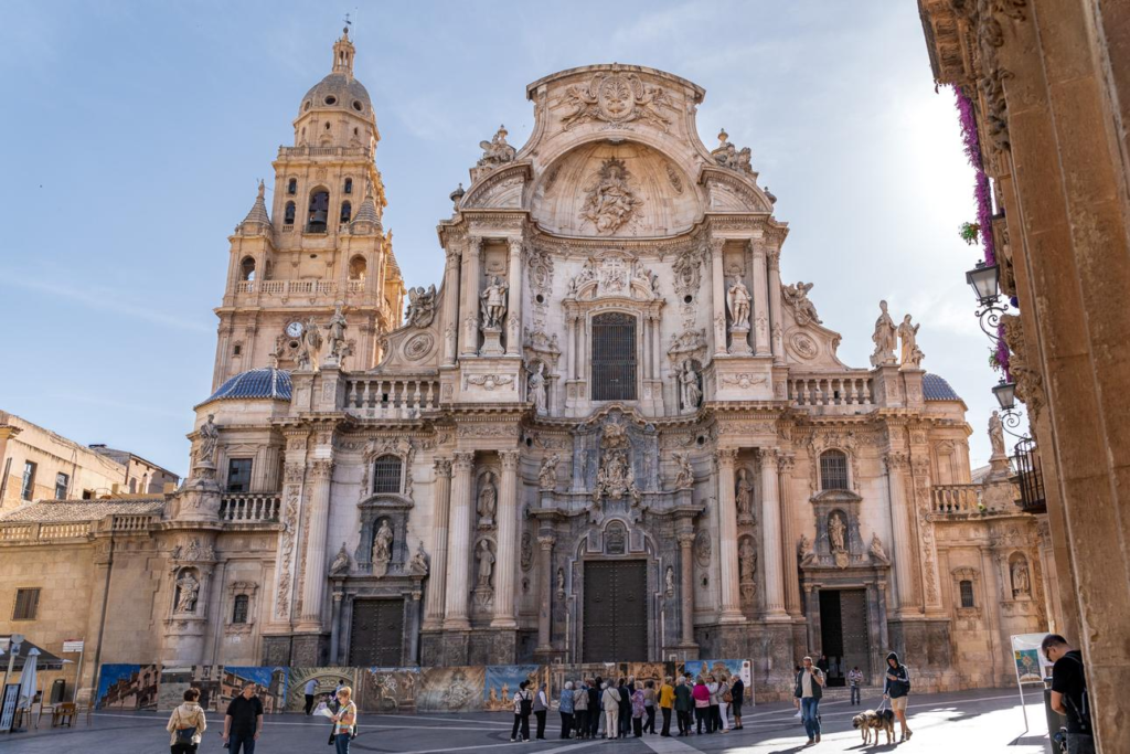 Visitors exploring the Cathedral of Murcia in Spain, a historic landmark with baroque architecture.