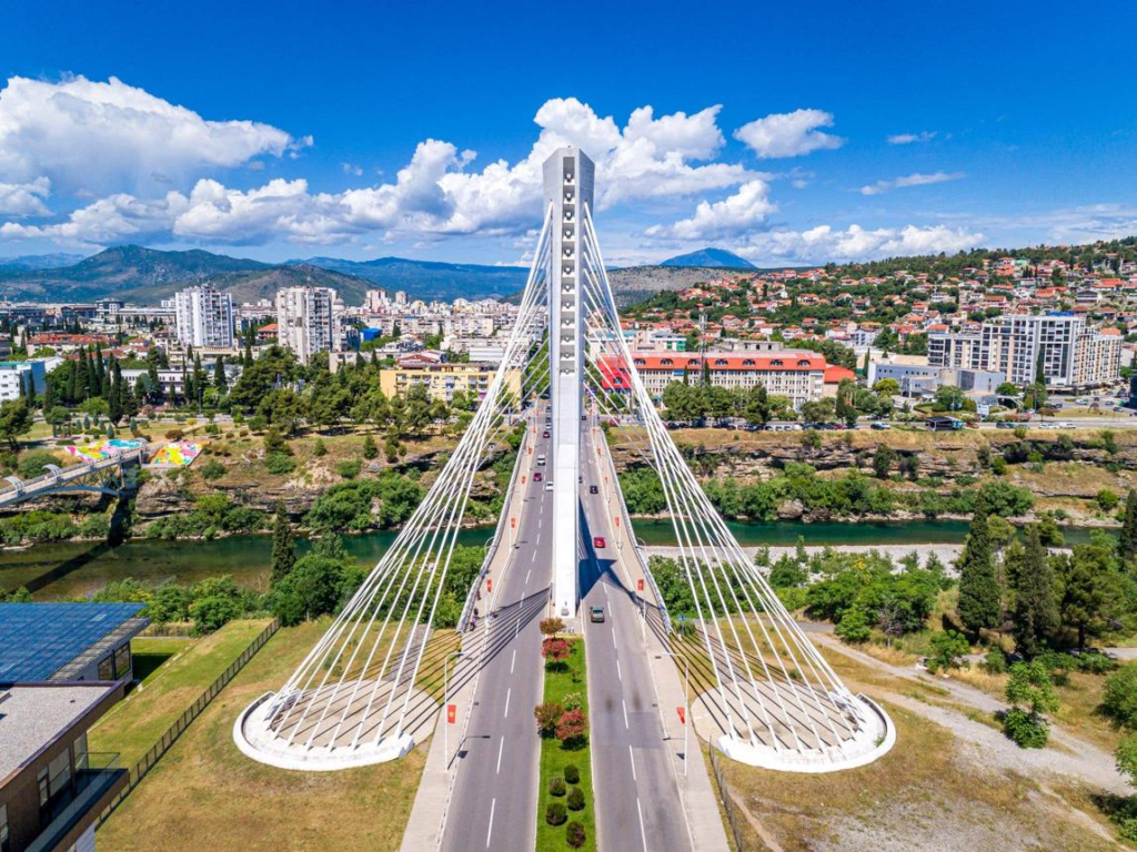 Visitors walking near the Millennium Bridge in Podgorica, Montenegro, a modern landmark spanning the Morača River.