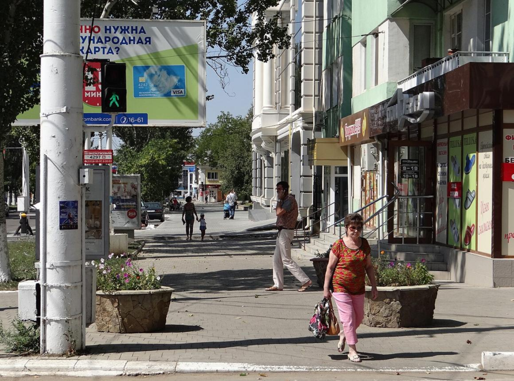 Visitors walking through streets in Tiraspol with shops, cafés, and Soviet-era buildings in the city center.