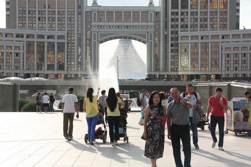 People walking through Astana streets with shops, cafés, and modern city activity