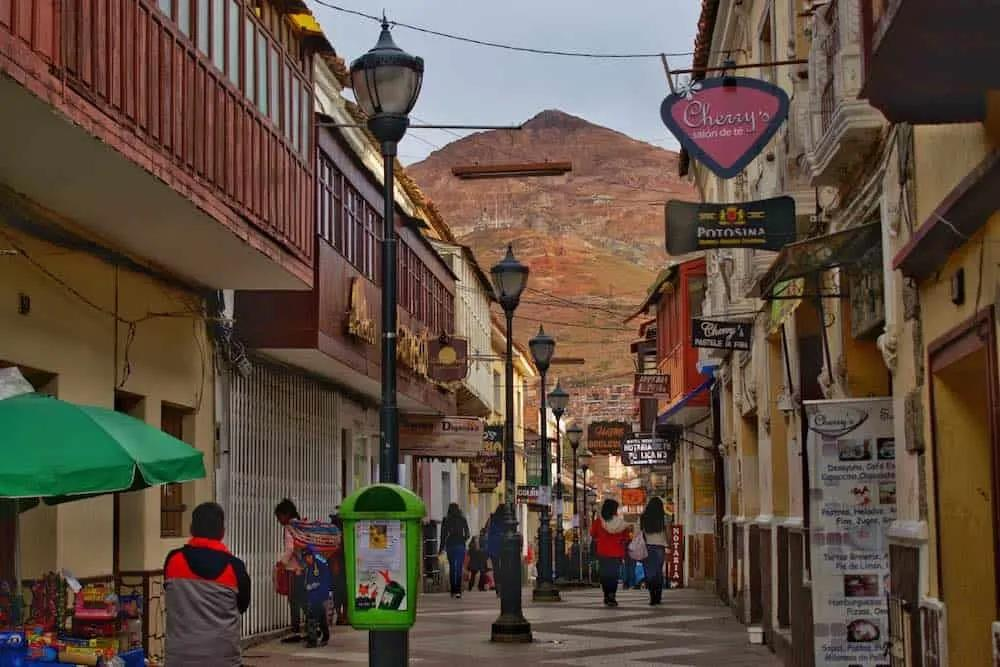 Visitors walking through streets in Potosí with local shops, cafés, and colonial architecture.