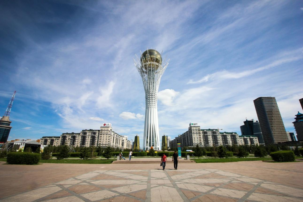 Tourists visiting Bayterek Tower in Astana with its iconic modern design and city surroundings.