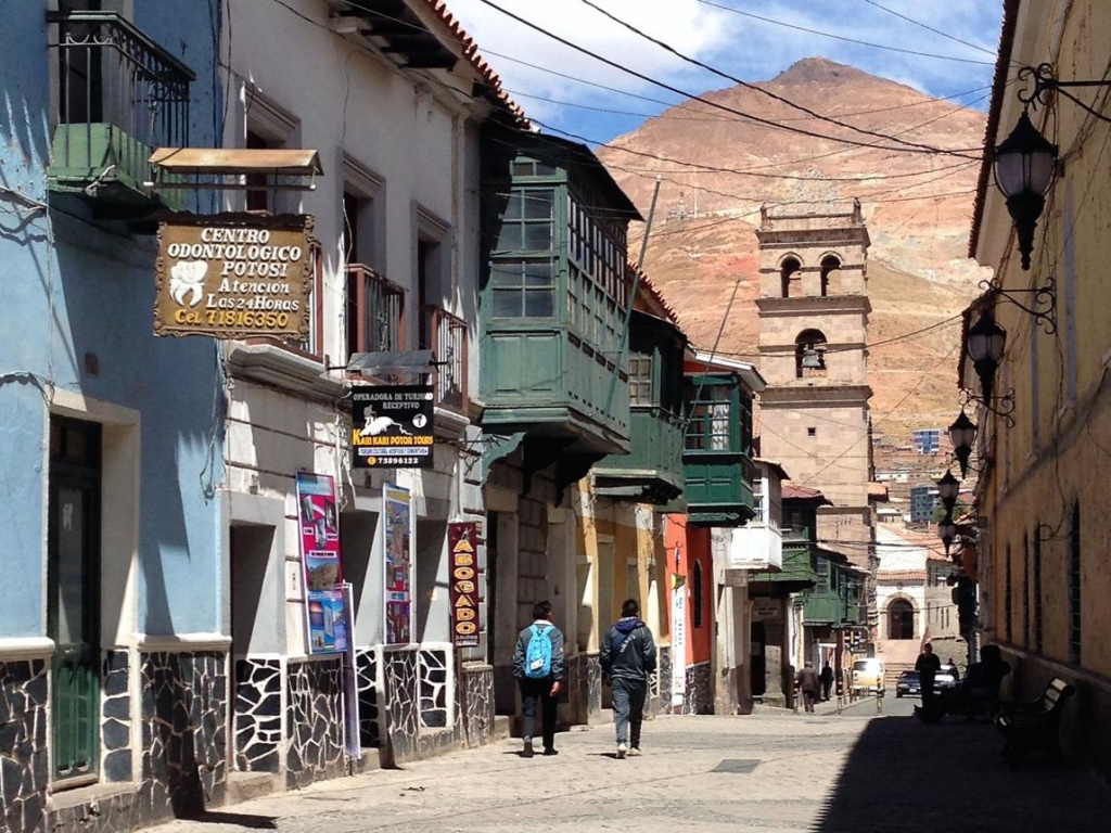Visitors walking through streets in Potosí with local shops, cafés, and colonial-style architecture.