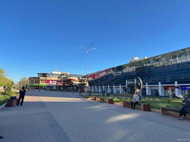 Visitors walking through streets in Karaganda with shops, cafés, and pedestrian activity.