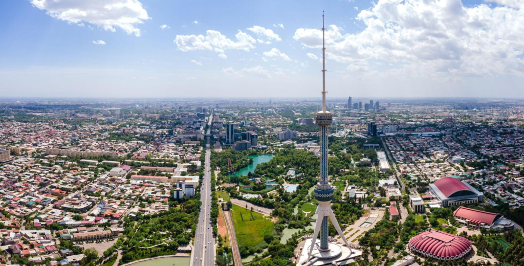 A panoramic aerial view of Tashkent showing the cityscape, modern buildings, and distant mountains in Uzbekistan.