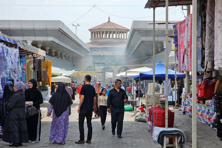Visitors walking through streets in Tashkent with shops, cafés, and pedestrian activity.