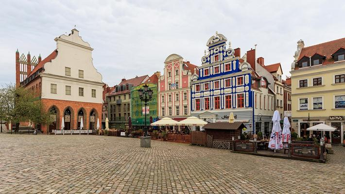 Locals and visitors exploring a bustling market in Szczecin with shops, stalls, and community activity.