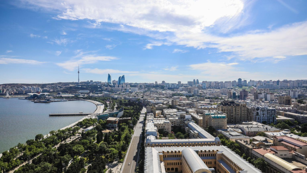 A panoramic aerial view of Baku showing the cityscape, Caspian Sea coastline, and the Flame Towers in Azerbaijan.