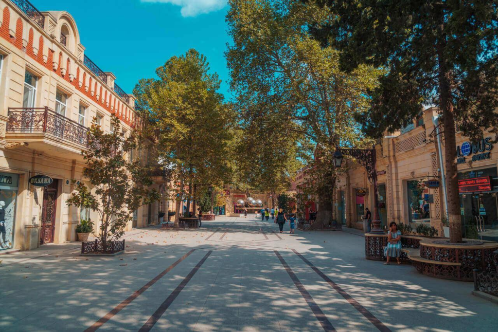 Visitors walking through streets in Ganja with local shops, cafés, and pedestrian activity.