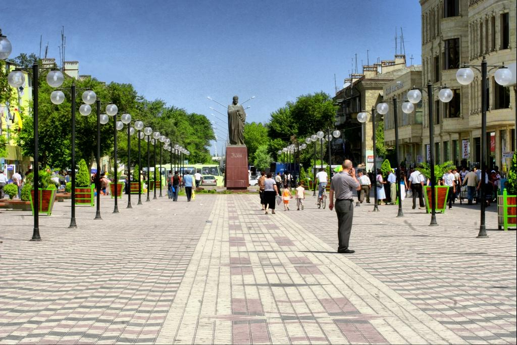 Visitors walking through streets in Sumqayit with local shops, cafés, and pedestrian activity.