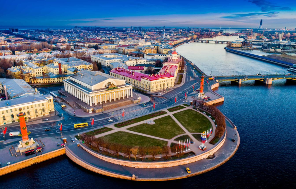 A panoramic aerial view of Saint Petersburg showing the cityscape, the Neva River, bridges, and the Winter Palace in Russia.